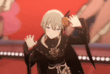 a girl in a black dress with a rose in her hair is waving her hands .