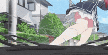 a girl in a skirt is standing in front of a car windshield .