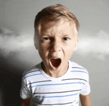 a young boy is screaming with his mouth open and smoke coming out of his mouth .