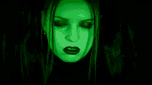 a close up of a woman 's face with a green light behind her
