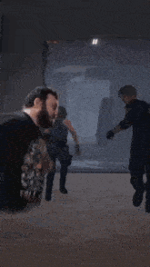 a man wearing a t-shirt that says ' colt ' on it stands in a dark room