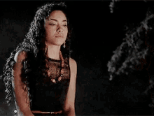 two women are standing next to each other in a dark room .