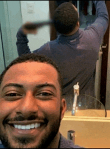 a man taking a selfie in front of a mirror and smiling