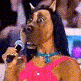 a dog is holding a microphone in front of a crowd .