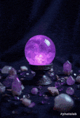 a purple crystal ball is surrounded by purple rocks and crystals
