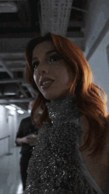 a woman with red hair is standing in a dark room