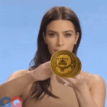 a woman holding two dalpy coins in front of her face
