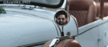 a man in sunglasses is reflected in a rear view mirror