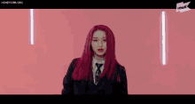 a girl with red hair is wearing a suit and tie .