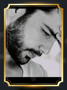 a black and white photo of a man with a beard and a gold frame