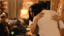 a man and a woman are hugging in a living room
