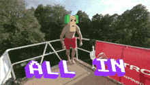 a man with a cardboard box on his head is jumping off a diving board and the words all in are above him