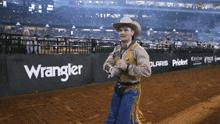 a cowboy stands in front of a wrangler advertisement