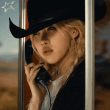 a woman wearing a cowboy hat talking on a phone