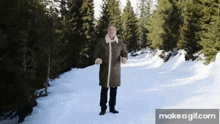 a man in a fur coat is standing in the snow .