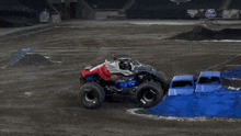 a monster truck is doing a trick on a dirt track with a jcb banner in the background