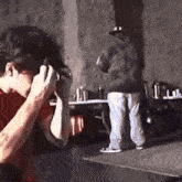 a man in a red shirt takes a picture of another man