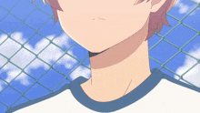 a close up of a person 's neck with a chain link fence behind them