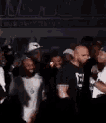 a group of people are standing in a dark room and dancing .