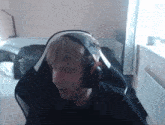 a man wearing headphones is sitting in a chair in a room .