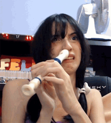 a woman is playing a flute in front of a fel sign