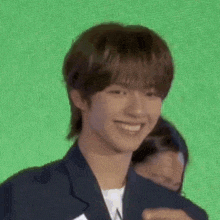 a young man in a suit is smiling and looking at the camera .