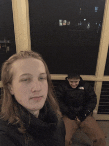 a boy wearing a north face jacket sits next to a girl