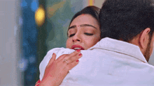 a man is hugging a woman who is wearing a ring on her finger