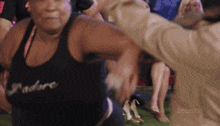 a woman wearing a black tank top that says adore