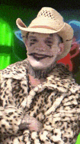 a man wearing a cowboy hat and a leopard print coat has a tattoo on his neck that says " i love you "