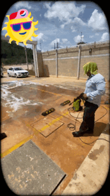 a man is using a high pressure washer in a parking lot with a picture of a sun behind him
