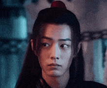 a close up of a man 's face with long hair and a red ponytail