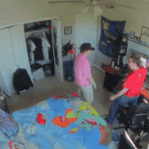 two men dancing in a bedroom with a pokemon tapestry hanging on the wall
