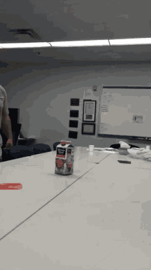 a carton of milk sits on a table in front of a whiteboard
