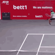 a tennis player is swinging a racket on a court in front of an ad for bett1
