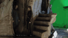 two people standing in a cave with a green screen behind them that says src tc