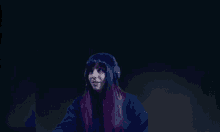 a woman with purple hair is wearing headphones and a black shirt