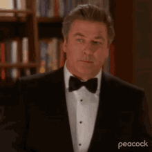 a man is wearing a tuxedo and bow tie .