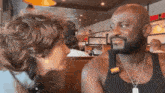a man and a woman are sitting at a table in a restaurant and looking at each other .
