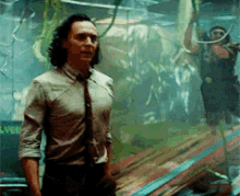 a man in a suit and tie is standing in a room with a snake in the background .
