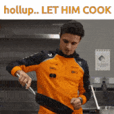 a man in an orange shirt is cooking in a kitchen with the words hollup let him cook above him