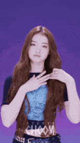 a woman with long red hair is wearing a blue shirt that says studio choom