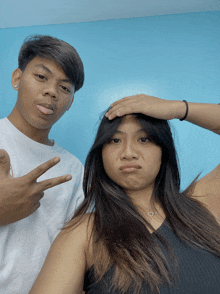 a man and a woman are posing for a picture and the woman is making a face