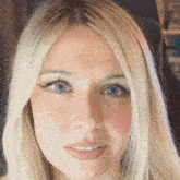 a close up of a woman with blonde hair and blue eyes