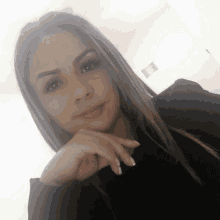 a woman in a black shirt has her hand on her face
