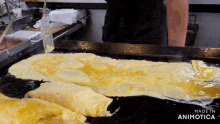a large omelet is being cooked on a griddle with the words made in animotica below it