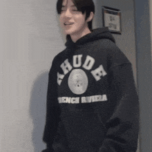 a man wearing a black hoodie that says rude