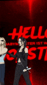 two women singing in front of a red sign that says hell