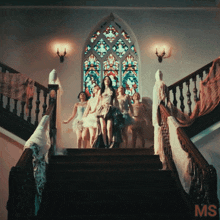 a group of women are standing on a set of stairs with ms written on the bottom