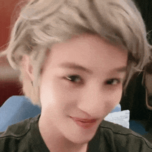 a close up of a woman 's face with short blonde hair making a funny face .